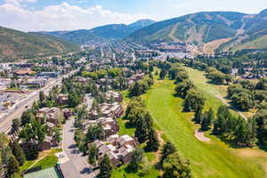 Aerial perspective of suburban area with mountains and a golf course