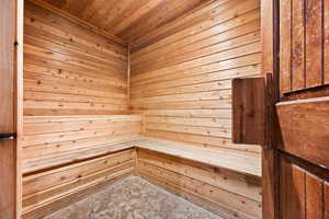 Sauna / steam room featuring wooden ceiling and wooden walls