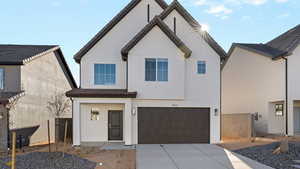 View of front of property with stucco siding, a garage, and concrete driveway
