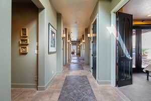 Hallway with baseboards and tile patterned floors