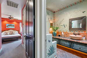 Bathroom with tasteful backsplash, vanity, ensuite bathroom, tile patterned flooring, and a ceiling fan