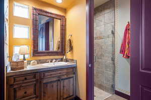 Full bath with vanity and a shower stall