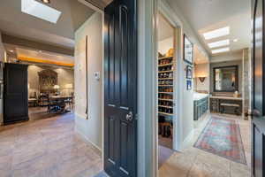Corridor featuring a skylight, recessed lighting, and light tile patterned flooring