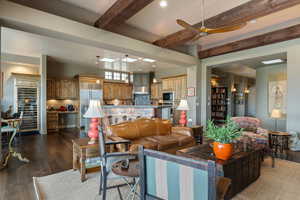 Living room with ceiling fan, dark wood-style flooring, beam ceiling, and recessed lighting