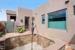 Exterior space featuring stucco siding and a gate