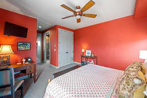 Carpeted bedroom featuring a closet and ceiling fan