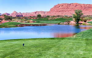 Water view with a mountainous background and a golf course