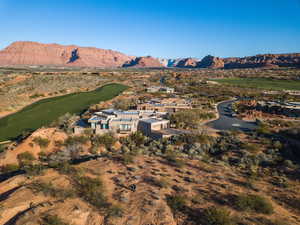 Aerial overview of property's location with a mountainous background, a golf course, and nearby suburban area
