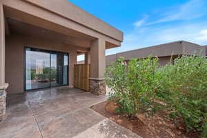 Doorway to property with stucco siding and a patio area