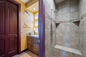 Full bathroom featuring a tile shower and vanity