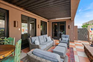 View of patio / terrace featuring an outdoor hangout area, a gate, and french doors