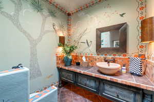 Bathroom with tasteful backsplash, vanity, and tile patterned flooring