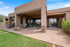 Rear view of property featuring stucco siding, a patio, a ceiling fan, and a lawn