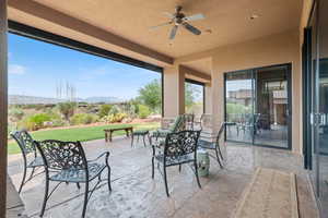 View of patio / terrace with a ceiling fan and a mountain view