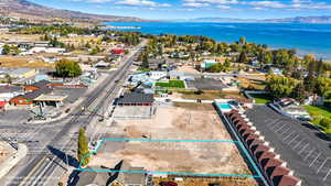 Aerial perspective of suburban area with property parcel outlined and a water and mountain view