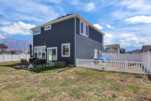 Back of property featuring a mountain view, a patio area, an outdoor hangout area, and a fenced backyard