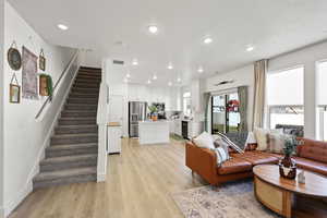 Living room with stairway, light wood-style flooring, recessed lighting, and a textured ceiling  Great Room Huge windows
