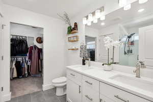 Double sinks with huge mirror Linen closet and large walk in closet