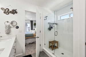 Full bathroom featuring ensuite bath, a stall shower, double vanity,