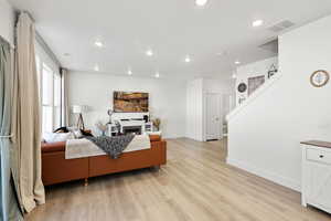 Living area with light wood-style floors, a fireplace, and recessed lighting