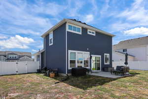 Back of property featuring a gate, a patio, a fenced backyard,