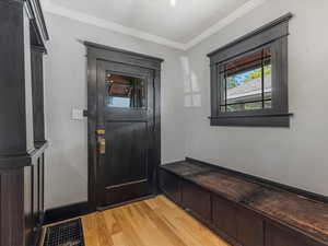 Mudroom featuring ornamental molding and light wood-style floors
