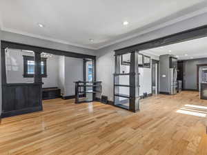 Entrance foyer with ornamental molding, light wood-style flooring, and recessed lighting