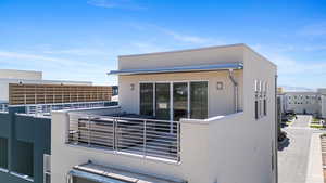 View of property exterior featuring a balcony and stucco siding