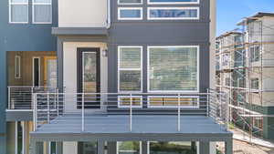 Entrance to property featuring a balcony and stucco siding