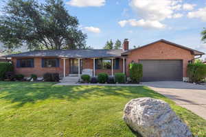 Ranch-style house with brick siding, an attached garage, and driveway
