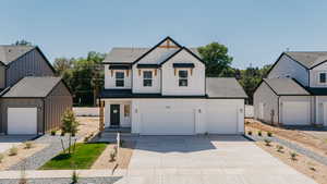 Modern inspired farmhouse featuring board and batten siding, a shingled roof, and concrete driveway