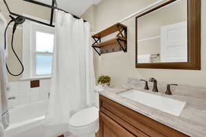 Full bath featuring vanity and shower / tub combo with curtain