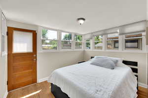 Bedroom featuring wood finished floors and multiple windows