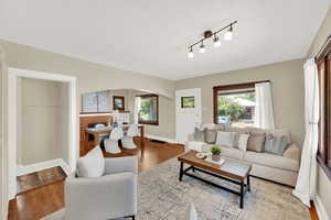 Living room with healthy amount of natural light, wood finished floors, arched walkways, and a brick fireplace