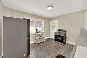 Kitchen with appliances with stainless steel finishes and baseboards