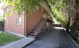 View of side of property featuring stairs and brick siding