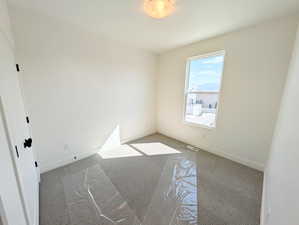 Carpeted empty room with baseboards