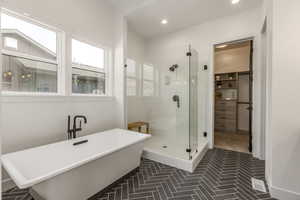 Bathroom featuring a shower stall, a freestanding tub, and recessed lighting