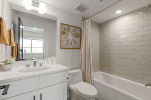 Bathroom featuring vanity and shower / bath combination with curtain