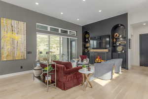 Living area featuring recessed lighting, wood finished floors, and a lit fireplace