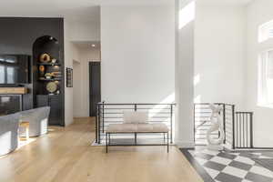Dining area with built in features, a towering ceiling, and wood finished floors