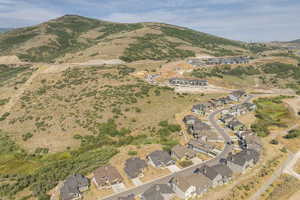 Aerial view of property and surrounding area with nearby suburban area and a mountain backdrop