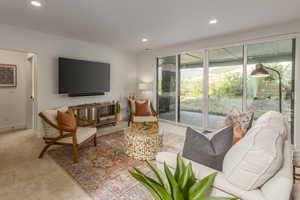 Carpeted living area with recessed lighting and baseboards