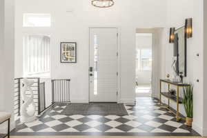 Foyer featuring baseboards and a towering ceiling