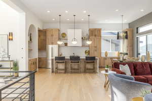 Kitchen featuring open shelves, light wood finished floors, open floor plan, recessed lighting, and freestanding refrigerator