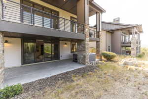 Rear view of property with a patio area and stone siding