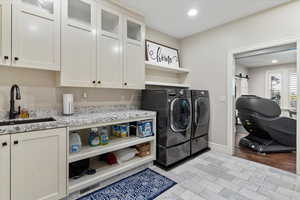Laundry area featuring independent washer and dryer, a barn door, and recessed lighting