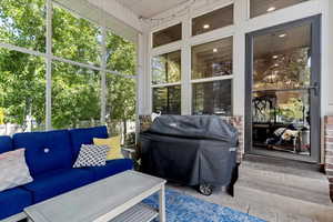 Sunroom featuring outdoor lounge area, view of scattered trees, and plenty of natural light