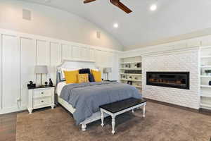 Bedroom featuring vaulted ceiling, recessed lighting, dark wood-style floors, a fireplace, and ceiling fan