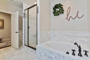 Full bath featuring a stall shower and a garden tub